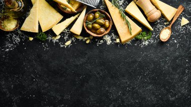 Süt ürünleri. Parmesan peyniri, zeytin ve atıştırmalıklar bir taş masada. Üst Manzara. Beton bir arka planda.