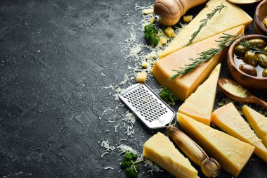 Parmesan cheese and snacks on a stone table. Top view. On a concrete background.