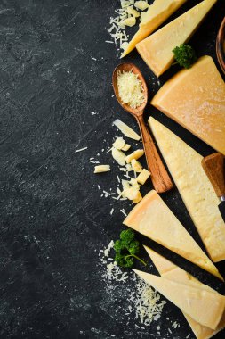Parmesan cheese and snacks on a stone table. Top view. On a concrete background.