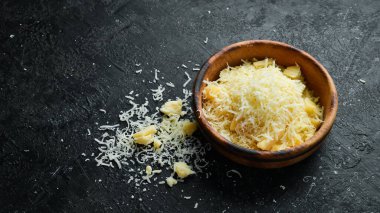 Grated parmesan cheese in a bowl. Cheese. Top view. On a stone background.