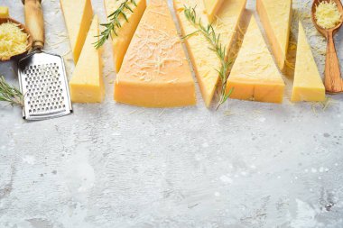 Parmesan cheese cut into pieces. Cheese. Side view. On a gray stone background.