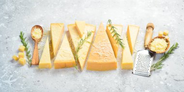 Parmesan cheese cut into pieces. Cheese. Side view. On a gray stone background.