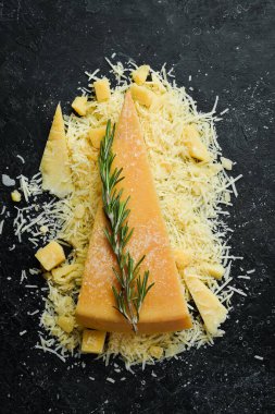 Pieces of hard parmesan cheese on a stone background. Food background. Free space for text.