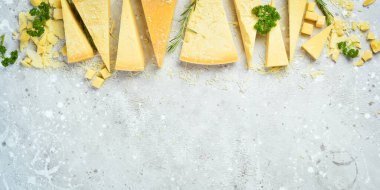 Cheese background. Triangular pieces of hard cheese on a stone background. Parmesan. Free space for text.