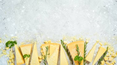 Cheese background. Triangular pieces of hard cheese on a stone background. Parmesan. Free space for text.