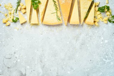 Cheese background. Triangular pieces of hard cheese on a stone background. Parmesan. Free space for text.
