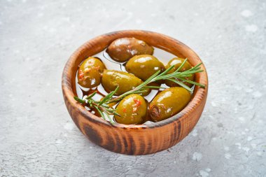 Tahta bir arka planda ahşap bir kasede marine edilmiş zeytin. Metin için boş alan.