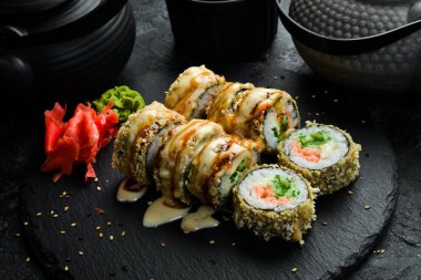 Siyah arka planda somon ve yılan balıklı ızgara suşi ruloları. Suşi menüsü. Japon yemeği..