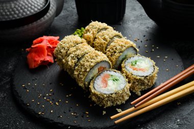 Grilled sushi rolls with salmon and eel on black background. Sushi menu. Japanese food.