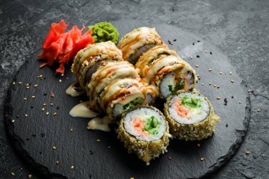 Grilled sushi rolls with salmon and eel on black background. Sushi menu. Japanese food.