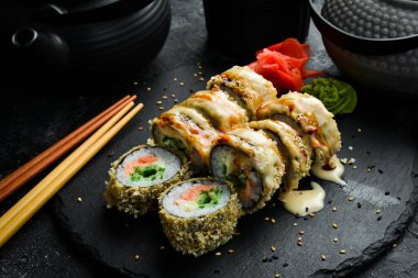 Grilled sushi rolls with salmon and eel on black background. Sushi menu. Japanese food.