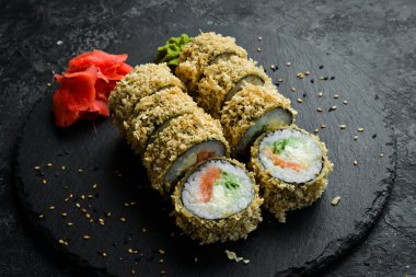 Grilled sushi rolls with salmon and eel on black background. Sushi menu. Japanese food.
