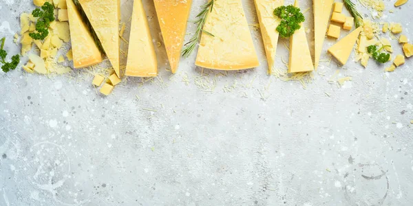 Cheese background. Triangular pieces of hard cheese on a stone background. Parmesan. Free space for text.