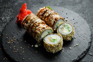 Delicious Sushi rolls with eel. Traditional Japanese food. On a black stone plate.