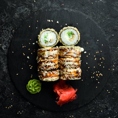 Delicious Sushi rolls with eel. Traditional Japanese food. On a black stone plate.