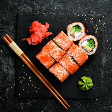 Sushi rolls with caviar. Traditional Japanese food. On a black stone plate. Top view.