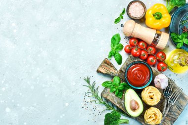 Food background. Vegetables, spices and pepper mill on a gray stone background. Top view. Free space for text.