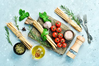 Grissini basil and spices on a gray stone background. Food. Top view.