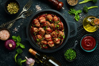 Kızartma tavasında köfte ve ekşi domates sosu. Üst Manzara. Taş bir arka planda.