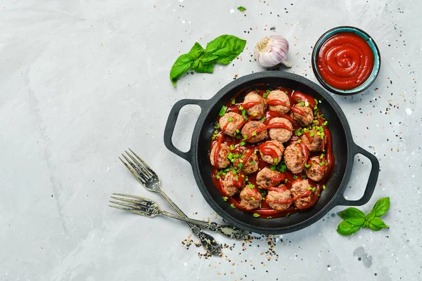 Kızartma tavasında köfte ve ekşi domates sosu. Üst Manzara. Taş bir arka planda.