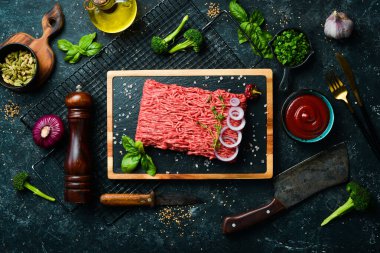- Et. Tabakta taze kıyma var. Pirzola hazırlığı. Üst Manzara. Taş bir arka planda.