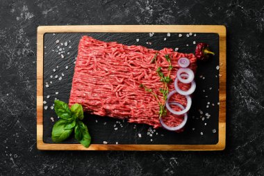 - Et. Tabakta taze kıyma var. Pirzola hazırlığı. Üst Manzara. Taş bir arka planda.