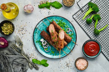 Geleneksel Türk kebabı. Siyah tabakta soğanlı şiş kebap BBBQ eti. Betondan eski bir masanın üzerinde. Üst görünüm.