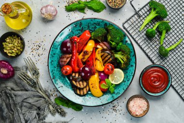 Yemek arkaplanı. Barbekü. Mavi yaratıcı tabakta ızgara sebze. Üst görünüm.