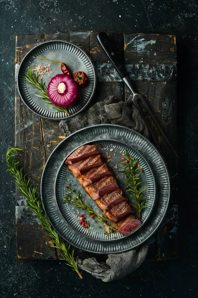 Gegrilde Gemarmerde Biefstuk Striploin Met Specerijen Een Zwarte Stenen Achtergrond — Stockfoto