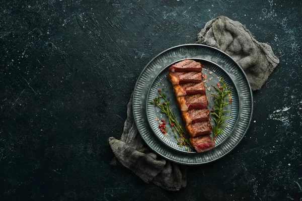 Gegrilde Gemarmerde Biefstuk Striploin Met Specerijen Een Zwarte Stenen Achtergrond — Stockfoto