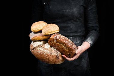 Fırın ürünleri: ekmek, ciabatta, baget. Siyah fırın arka planı.