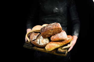 Fırın ürünleri: ekmek, ciabatta, baget. Siyah fırın arka planı.