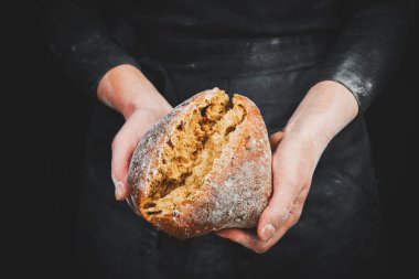 Kadınların elindeki güzel kokulu ciabatta, yemek fotoğrafçılığı tarifi fikri. Siyah fırın arka planı.