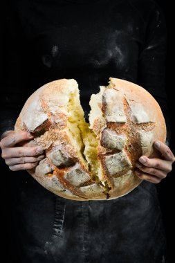 Kadınların elinde kokulu beyaz ekmek. Kara un pişirme arkaplanı.