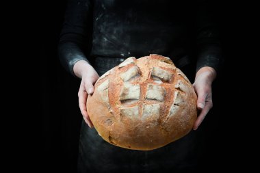 Kadınların elinde kokulu beyaz ekmek. Kara un pişirme arkaplanı.
