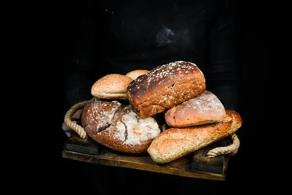 Fırın ürünleri: ekmek, ciabatta, baget. Siyah fırın arka planı.