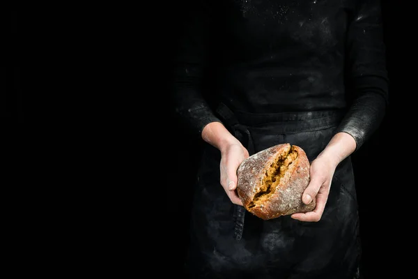 Fragrant ciabatta in women\'s hands, food photography recipe idea. Black baking background.