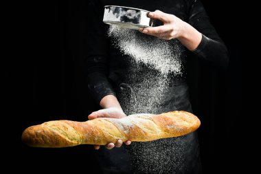 Ellerinde taze kokulu baget. Siyah aşçılık geçmişi. Siyah arkaplanda izole.