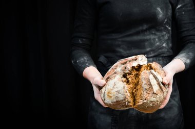 Ellerin un yüzünden kara ekmek kırışır. Siyah aşçılık geçmişi. Siyah arkaplanda izole.