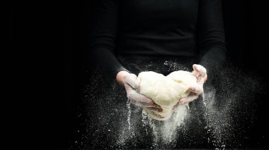 Ev yapımı unlu hamur ekmeği için şef elleriyle hamur pişirmek. Karanlık bir arka planda.