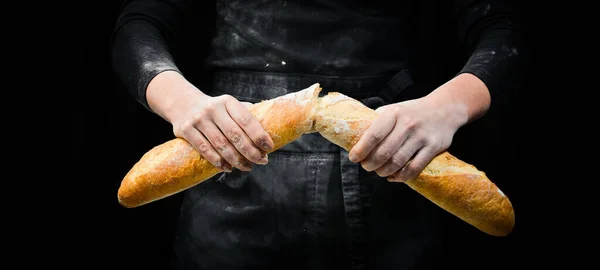 Frauenhände Zerbrechen Das Baguette Vereinzelt Auf Schwarzem Hintergrund — Stockfoto