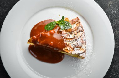 Tatlı. Tabakta karamel soslu bisküvi elmalı turta. Üst görünüm.