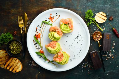 Kahvaltıda. Beyaz ekmeğin üstünde somon ve avokado sandviçi. Sağlıklı yiyecekler. Üst görünüm.