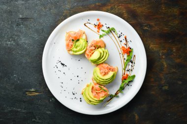 Kahvaltıda. Beyaz ekmeğin üstünde somon ve avokado sandviçi. Sağlıklı yiyecekler. Üst görünüm.