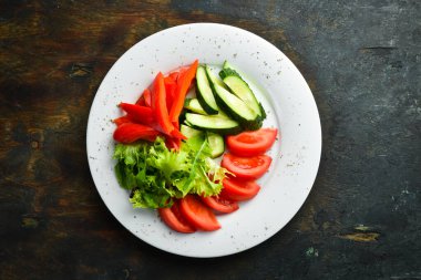 Tabakta çeşitli sebzeler. Taze sebze dilimleme: salatalık, domates, biber. Restoran menüsü. Üst görünüm.