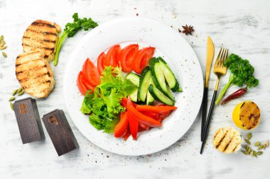 Tabakta çeşitli sebzeler. Taze sebze dilimleme: salatalık, domates, biber. Restoran menüsü. Üst görünüm.