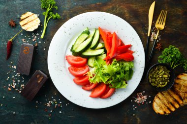 Tabakta çeşitli sebzeler. Taze sebze dilimleme: salatalık, domates, biber. Restoran menüsü. Üst görünüm.