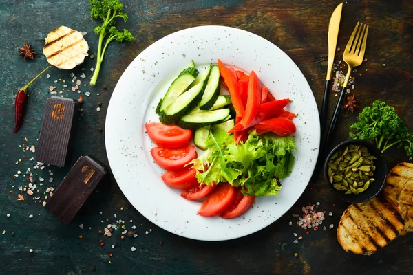 Tabakta çeşitli sebzeler. Taze sebze dilimleme: salatalık, domates, biber. Restoran menüsü. Üst görünüm.