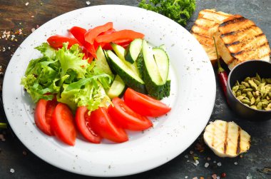 Tabakta çeşitli sebzeler. Taze sebze dilimleme: salatalık, domates, biber. Restoran menüsü. Üst görünüm.