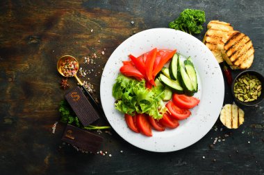 Tabakta çeşitli sebzeler. Taze sebze dilimleme: salatalık, domates, biber. Restoran menüsü. Üst görünüm.